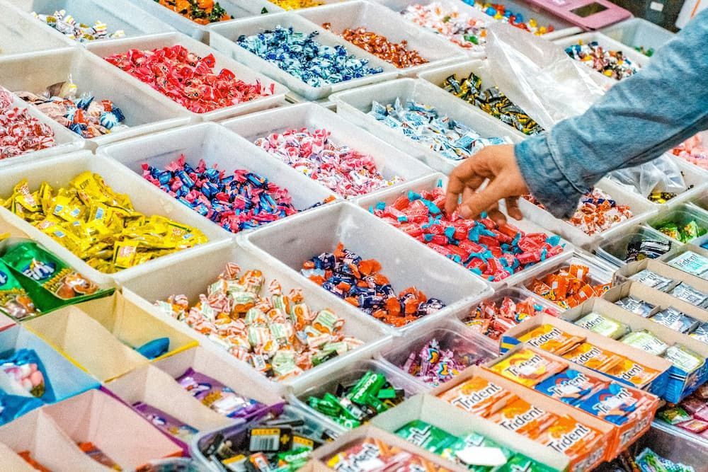 A Person Is Reaching for A Candy in A Candy Store — Mini Market Townsville Smoke Shop in Townsville City, QLD