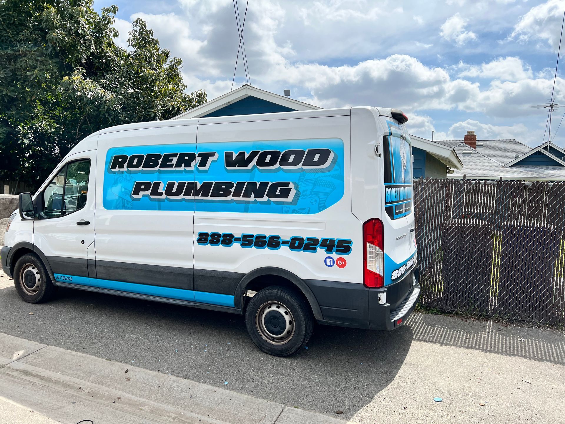 A robert wood plumbing van is parked on the side of the road.