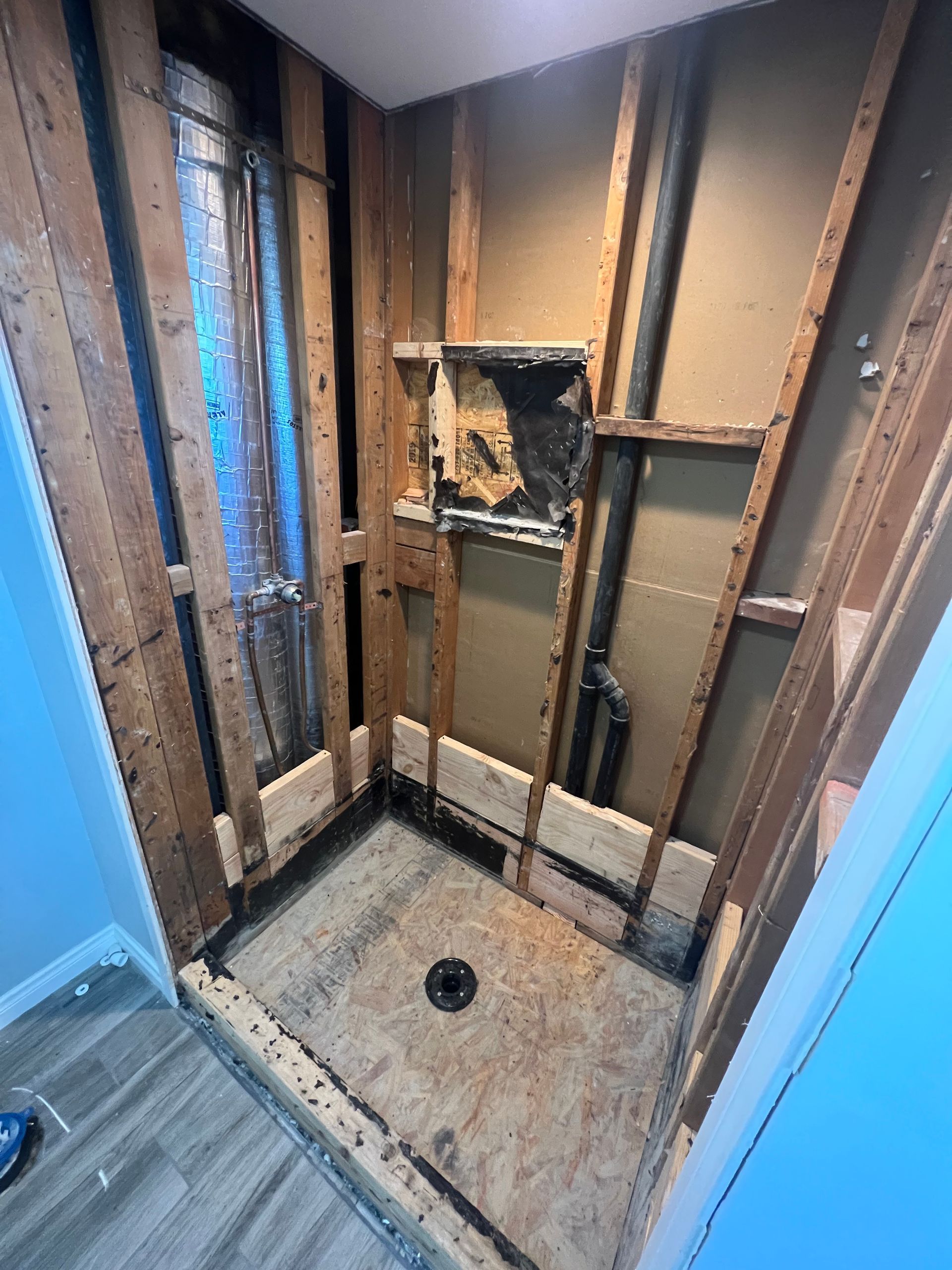 A bathroom with a shower stall being remodeled.