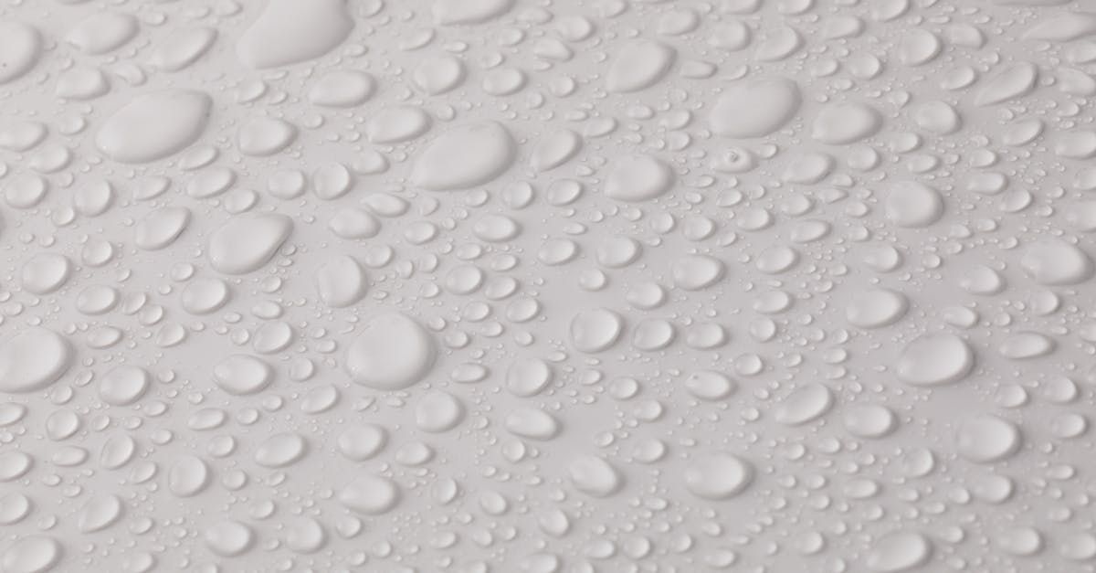 A close up of water drops on a white surface.