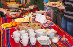 A table with plates of food and cups on it