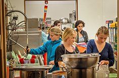 A group of women are cooking in a kitchen.