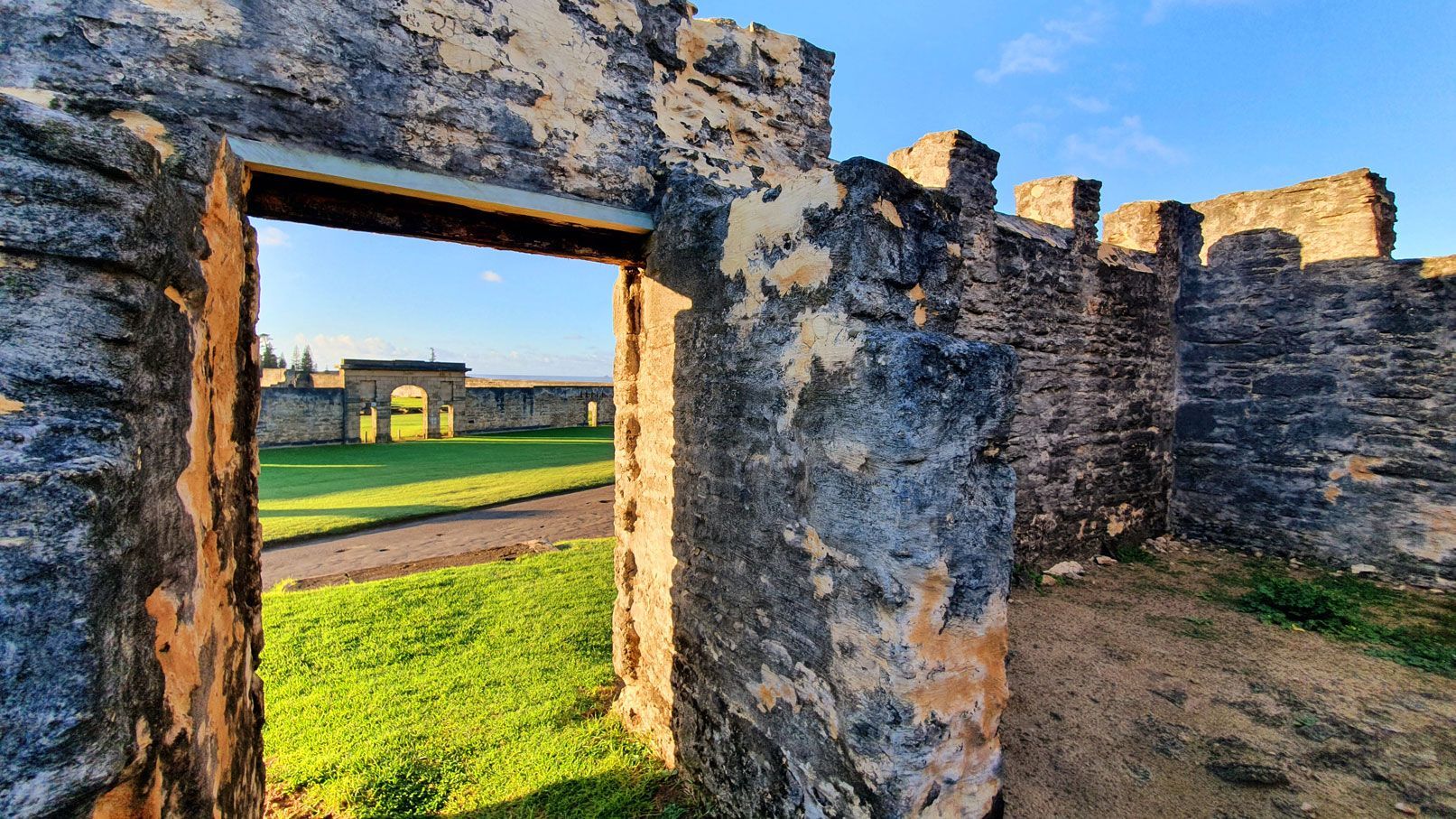 Ruins of a stone building with a doorway looking out onto a green lawn. Norfolk Island Trade Winds Seniors Sanctuary
