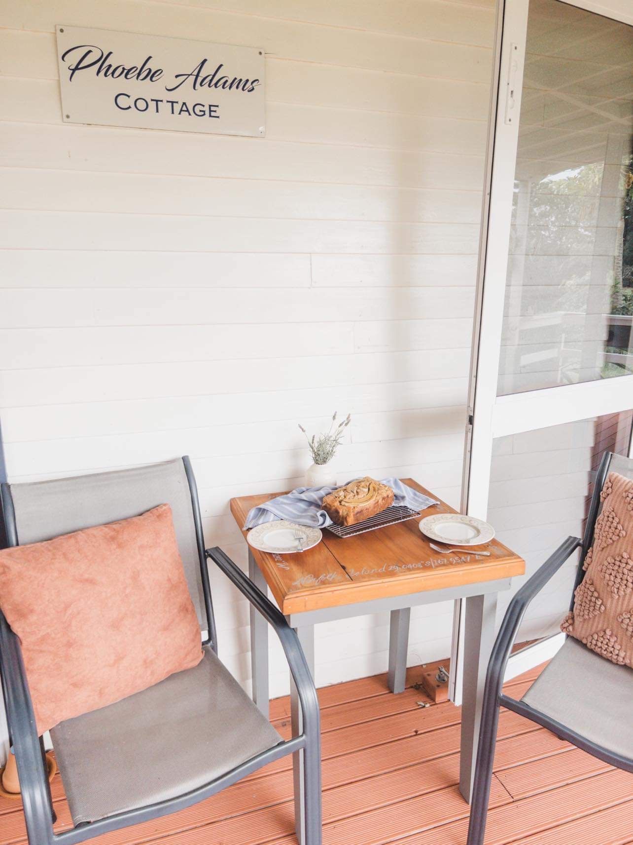 A small table set for tea on a porch with two chairs. Norfolk Island Trade Winds Seniors Sanctuary