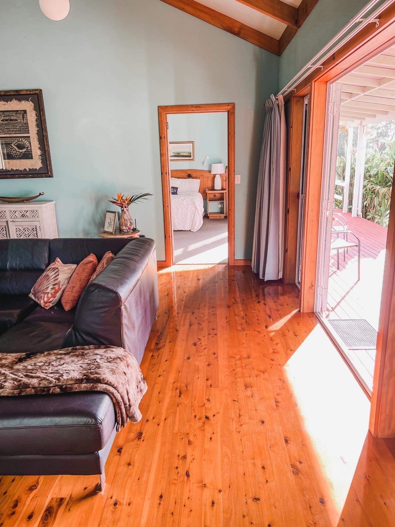 Living room with blue walls, hardwood floors, and a view into a bedroom. Norfolk Island Trade Winds Seniors Sanctuary