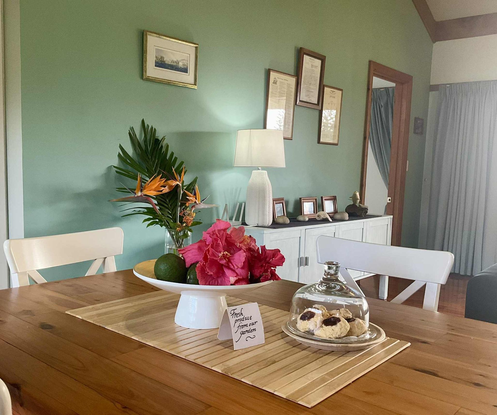 Dining room with table set for guests, featuring flowers, cookies. Norfolk Island Trade Winds Seniors Sanctuary