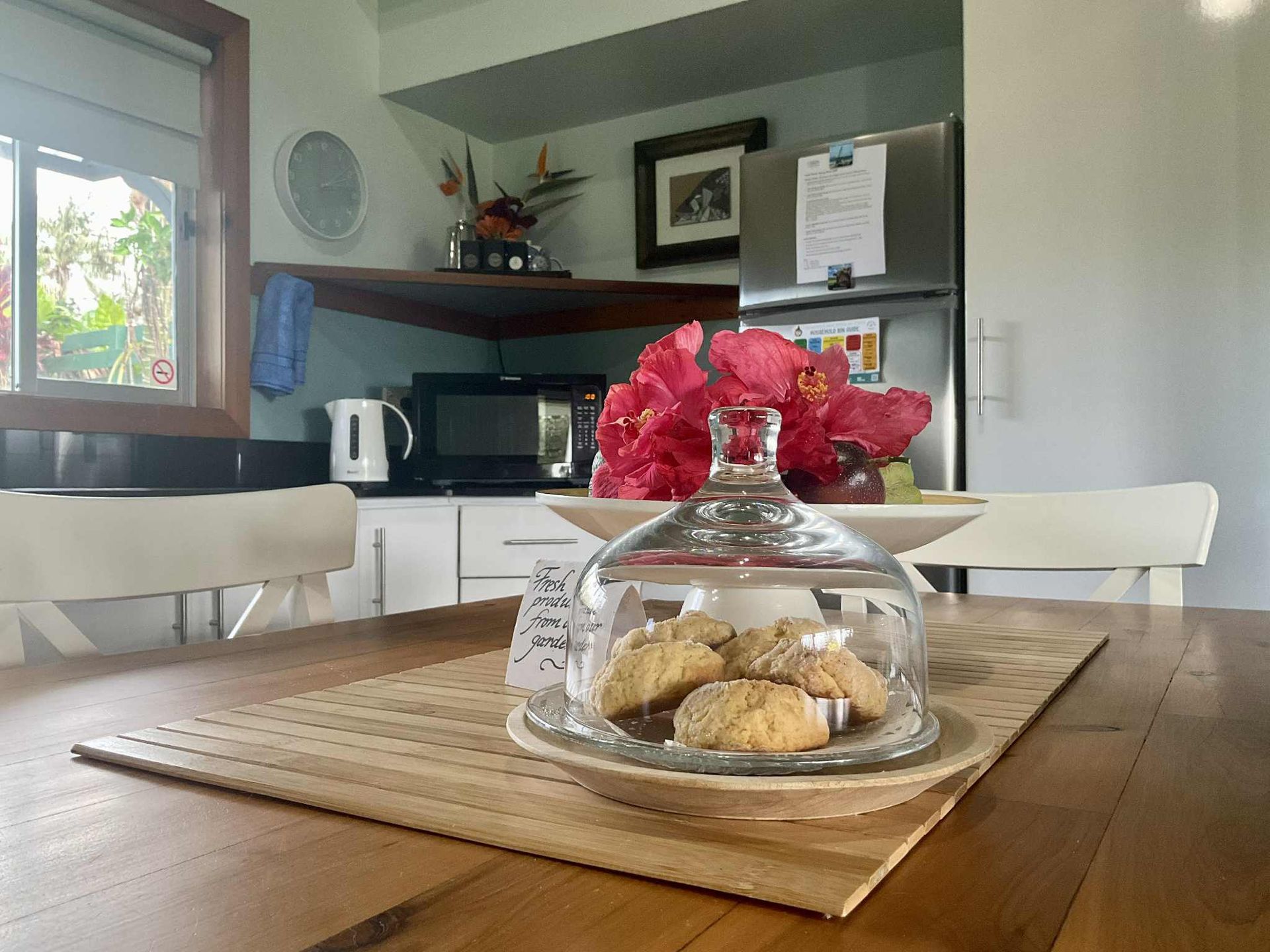 Cookies under glass cloche on a wood table, kitchen with white cabinets. Norfolk Island Trade Winds Seniors Sanctuary