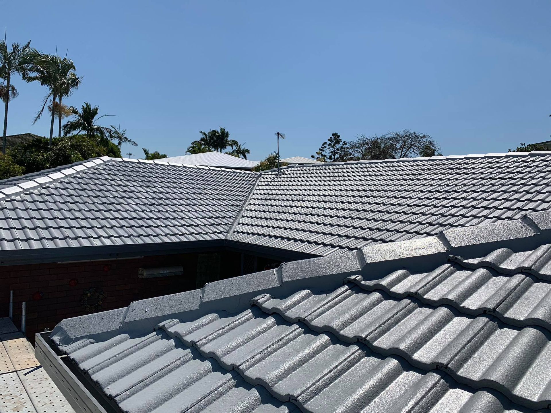 Gray Tiled Roof on a House Under a Bright Blue Sky — Roof Tek CQ in Rockhampton, QLD