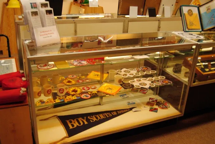 A glass display case of scouting flags and badges