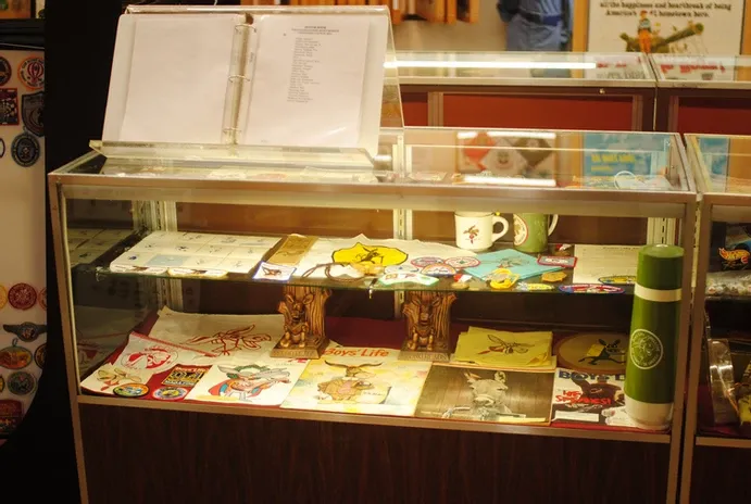 A tall glass display case of a number of scouting graphics