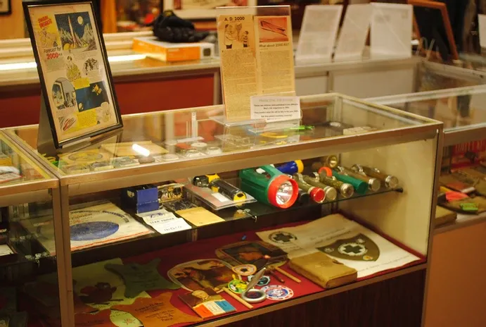 A short glass display case of flashlights and other scouting accessories