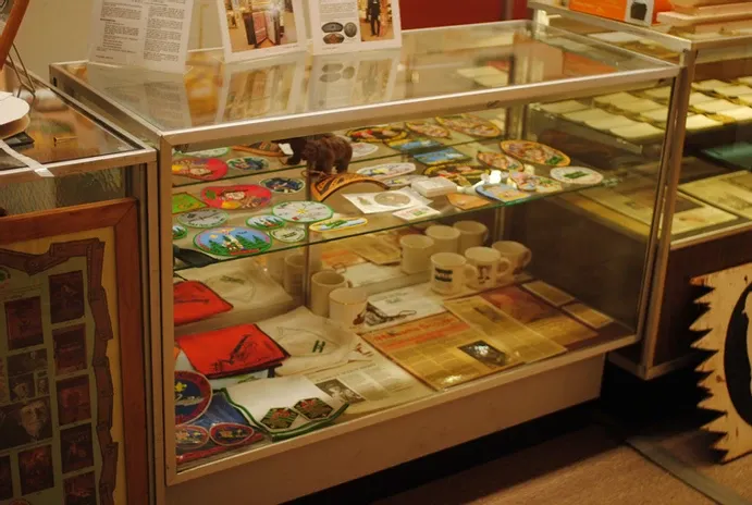 A short glass display case of scouting newspaper clippings and badges