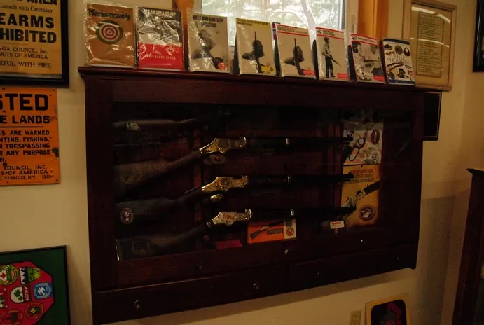 A shot of a wooden display case of rifles