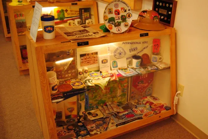 A glass display case of a large number of scouting flags