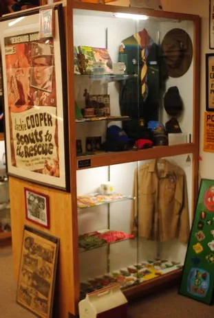 Tall display case of scouting memorabilia and clothing