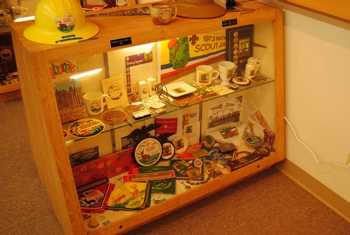 Glass display case of scouting flags, graphics and other collectibles