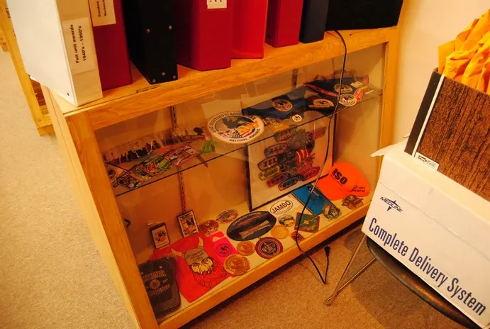 A glass display case of badges and scouting clothing