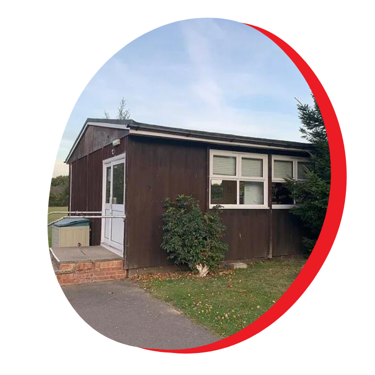 A small brown building with a white door and windows