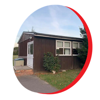 A small brown building with a white door and windows