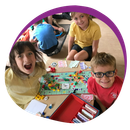 A group of children are sitting around a table playing a board game