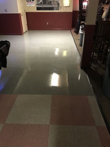A hallway with a checkered floor and a red wall.