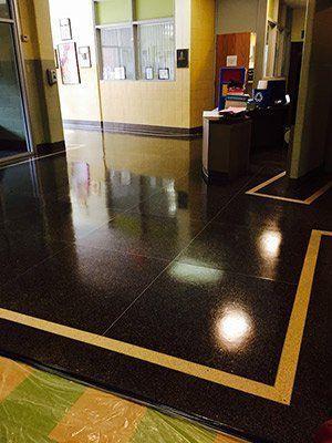A hallway with a shiny black floor and a yellow line on the floor.