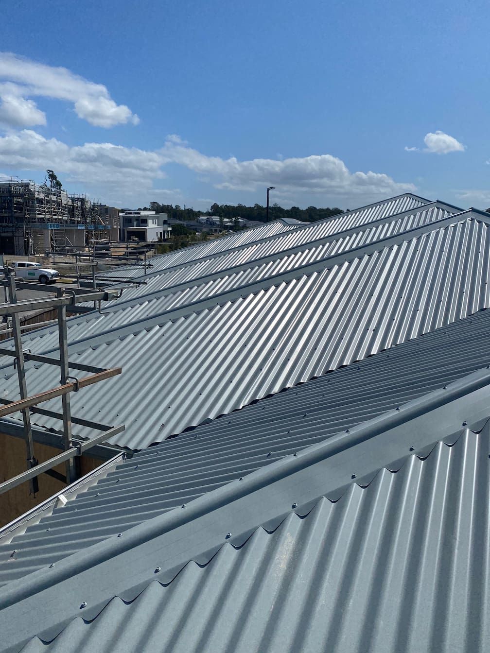 A close up of a metal roof with a blue sky in the background.