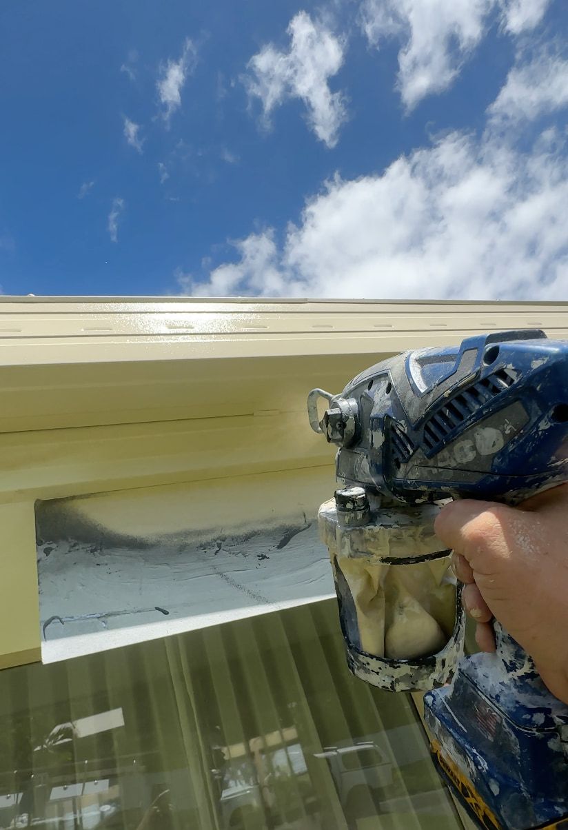 A person painting roof gutters.