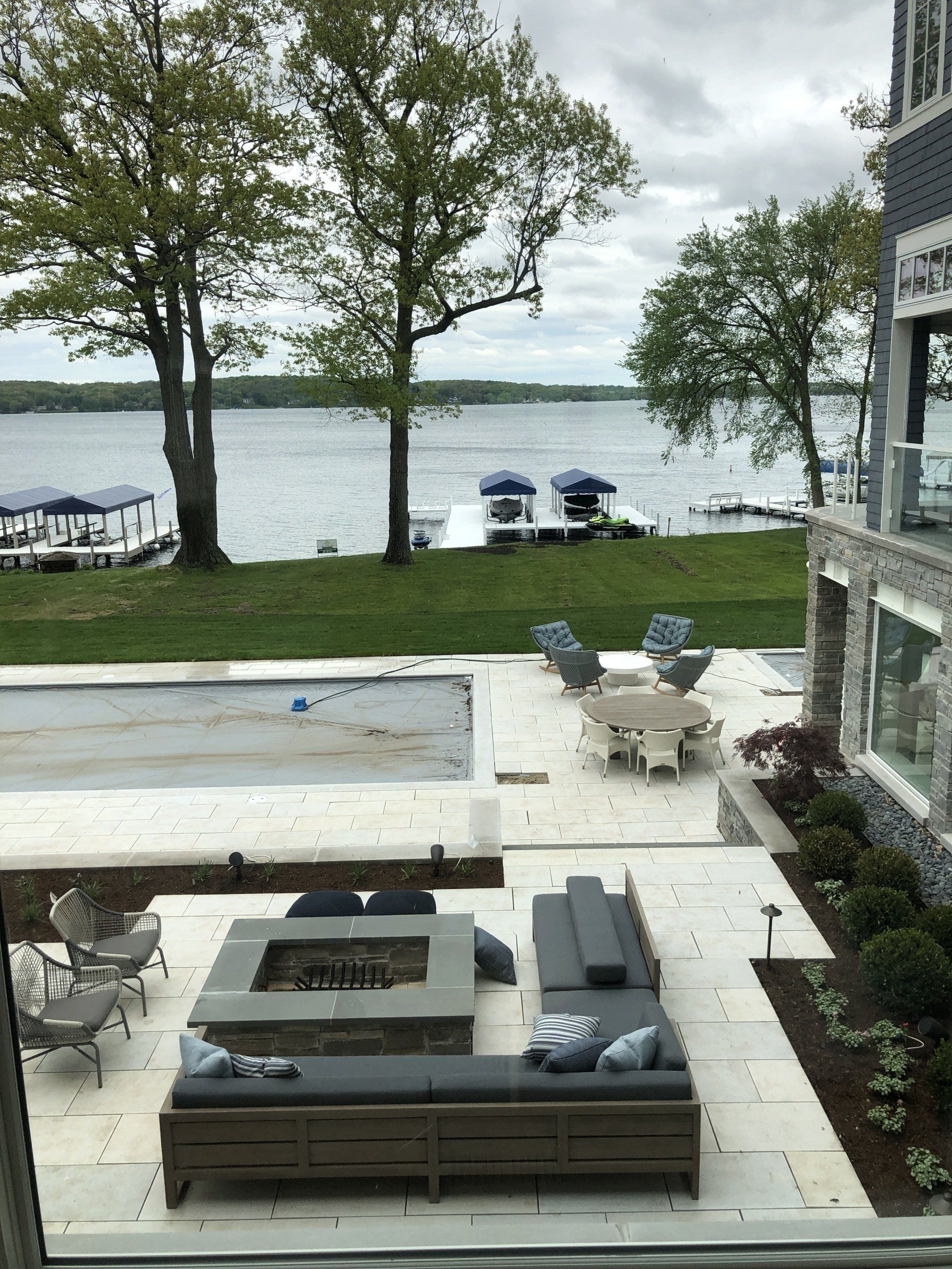 A view of a lake from a window with a fire pit in the middle