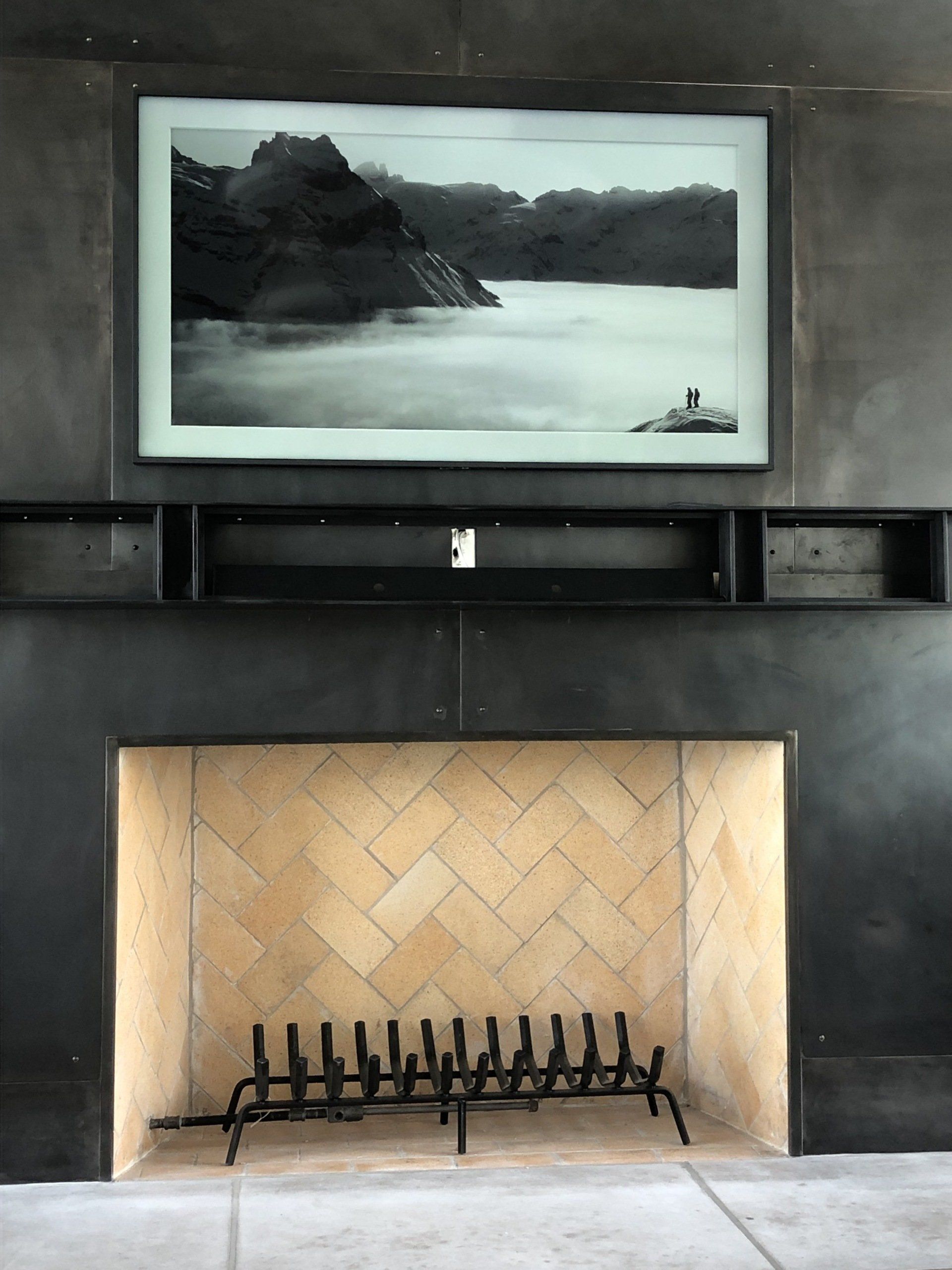 A fireplace with a picture on the wall above it