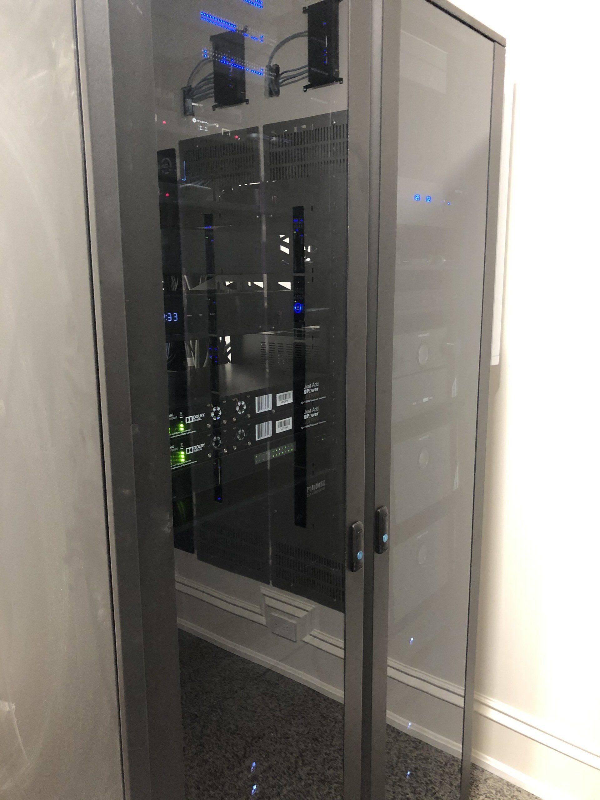 A glass door is open to a room with a lot of equipment in it.