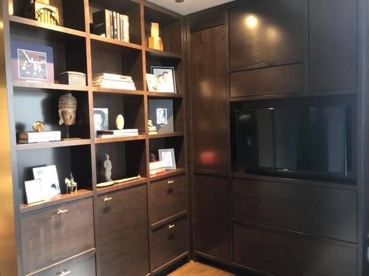 A room with lots of shelves and drawers and a tv