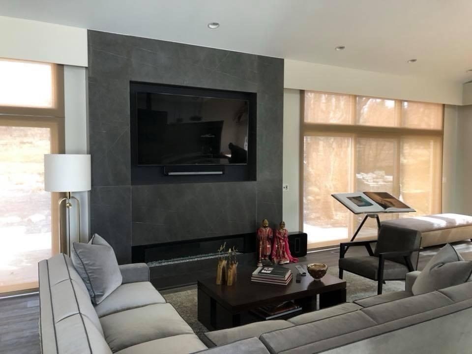 A living room with a fireplace and a flat screen tv on the wall.