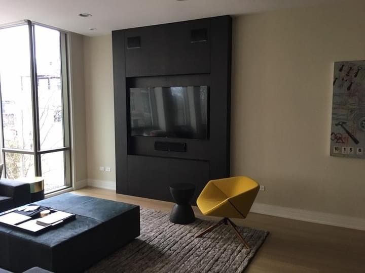 A living room with a large flat screen tv mounted to the wall