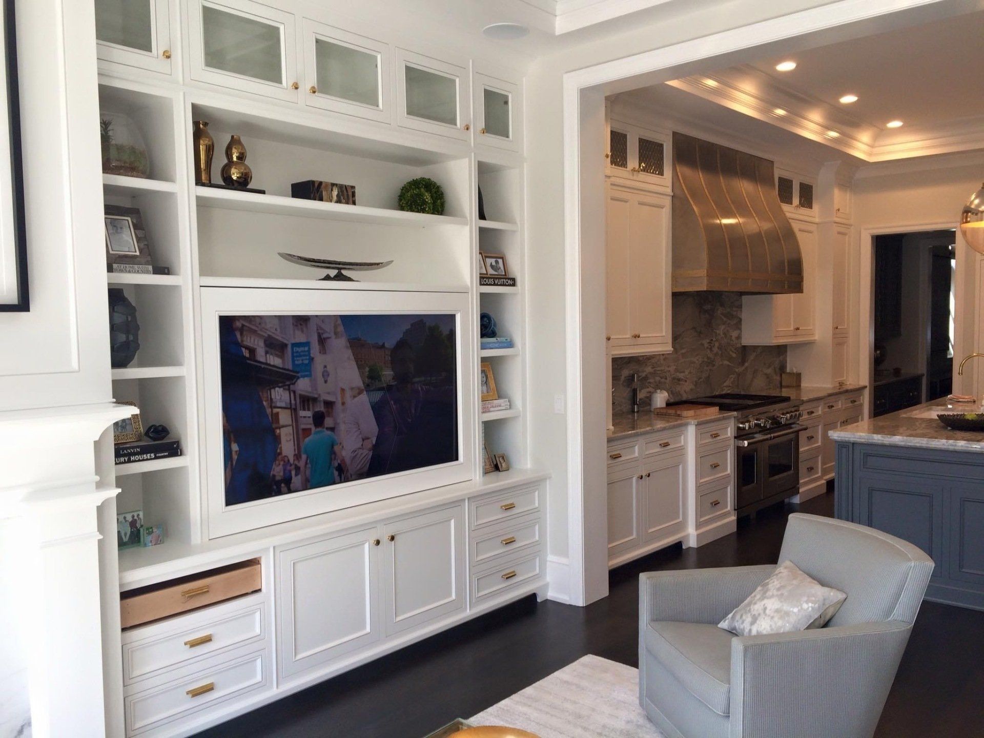 A living room with a television on the wall and a chair.