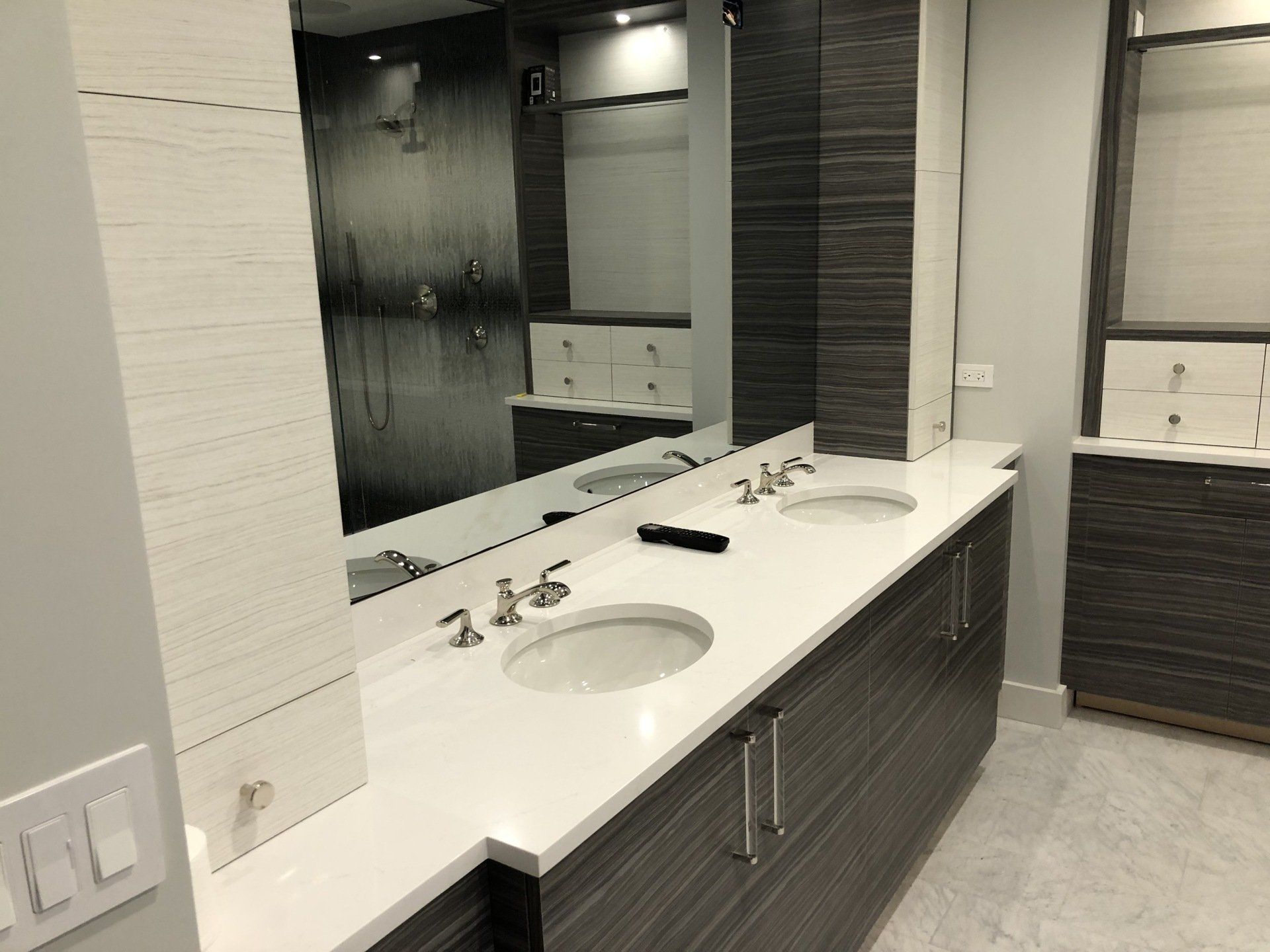A bathroom with two sinks and a large mirror.