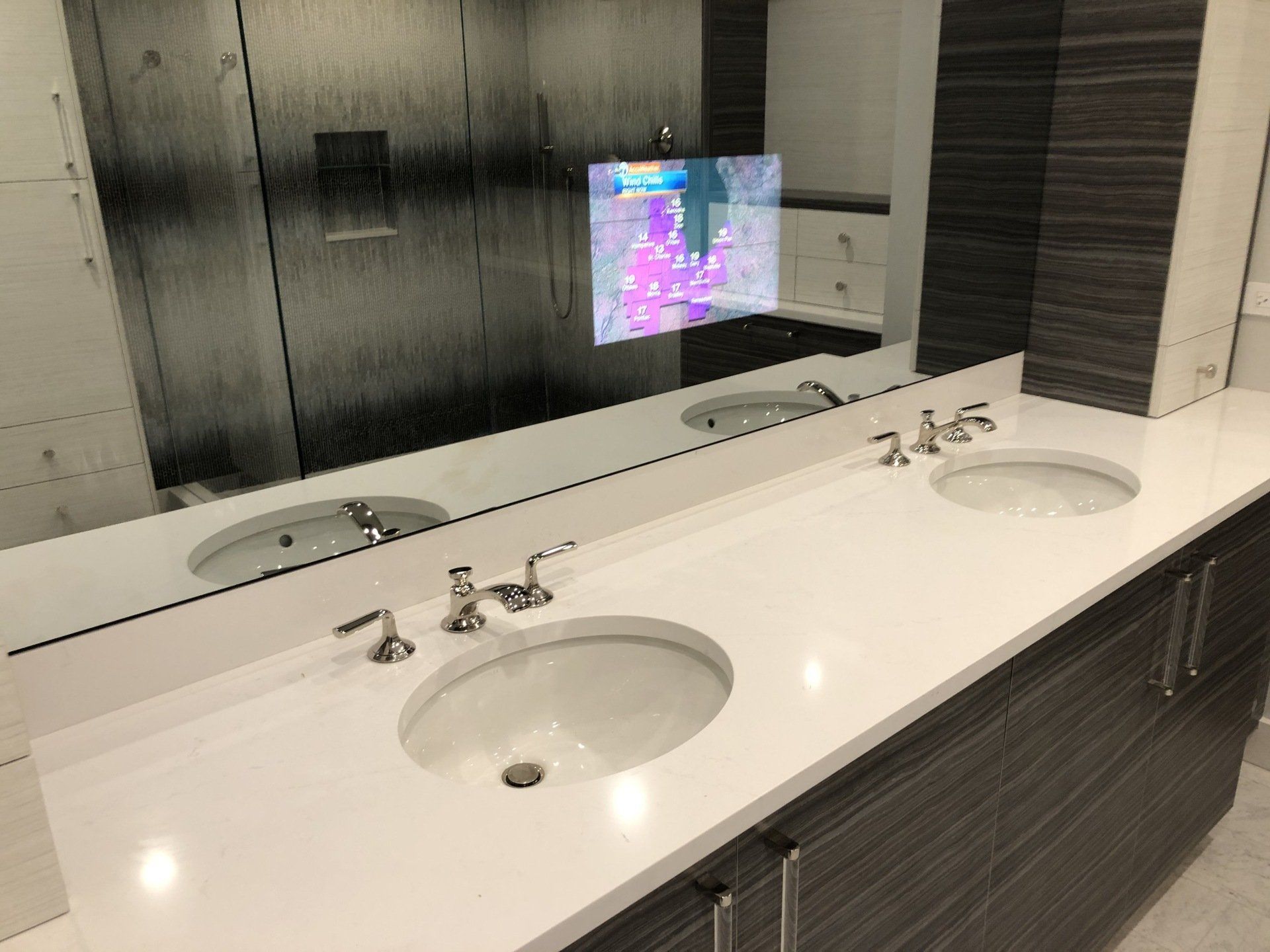 A bathroom with two sinks and a large mirror.