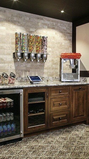 A kitchen with a popcorn machine , cereal dispensers , and a refrigerator.