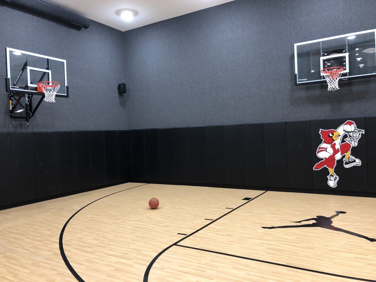 A basketball court with two basketball hoops and a basketball on the floor.