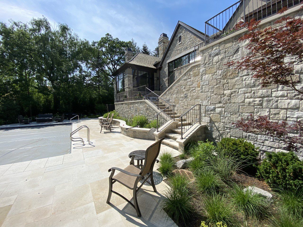 A chair is sitting on a patio next to a stone wall.