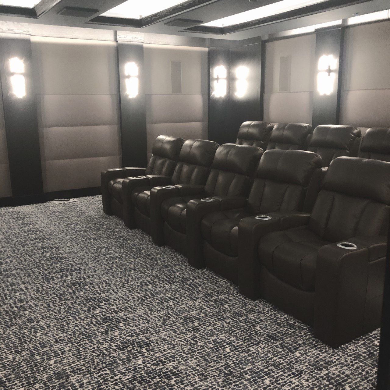 A row of black leather chairs in a theater