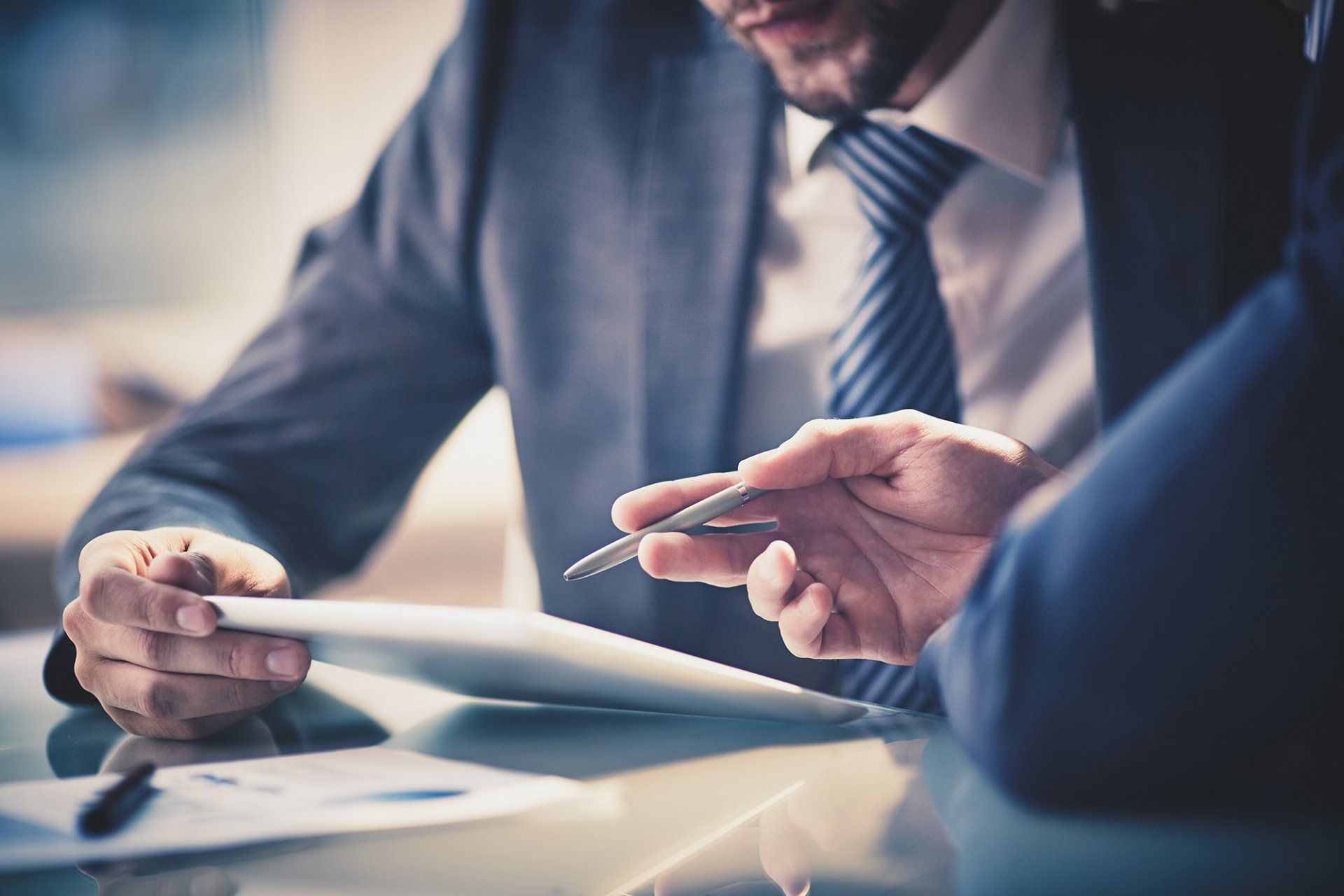 two young businessmen using touchpad at meeting
