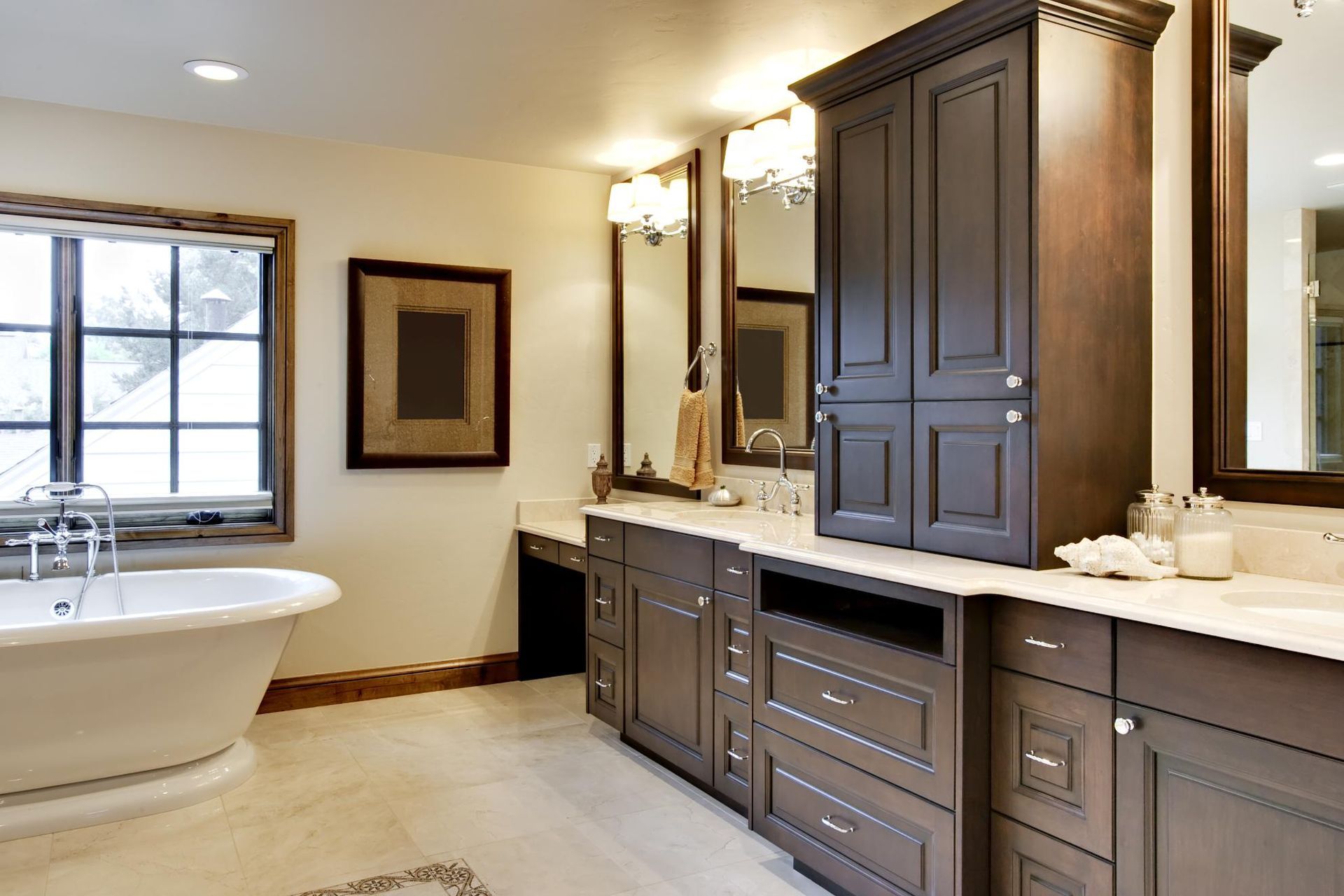 Elegant bathroom with dark brown cabinets, a white bathtub, and a large window.  Neutral tones create a relaxing space.