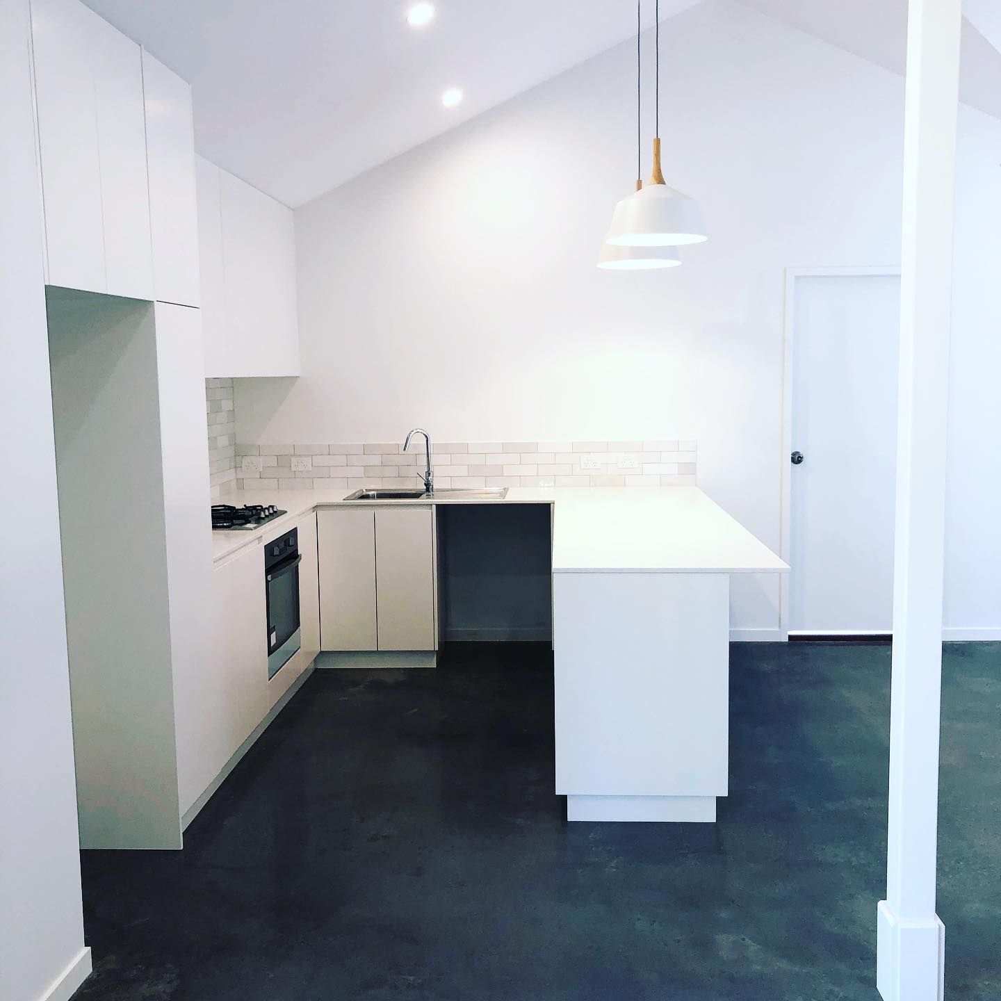 A Kitchen With White Cabinets And A Black Floor — Alstonville Kitchens In Alstonville, NSW