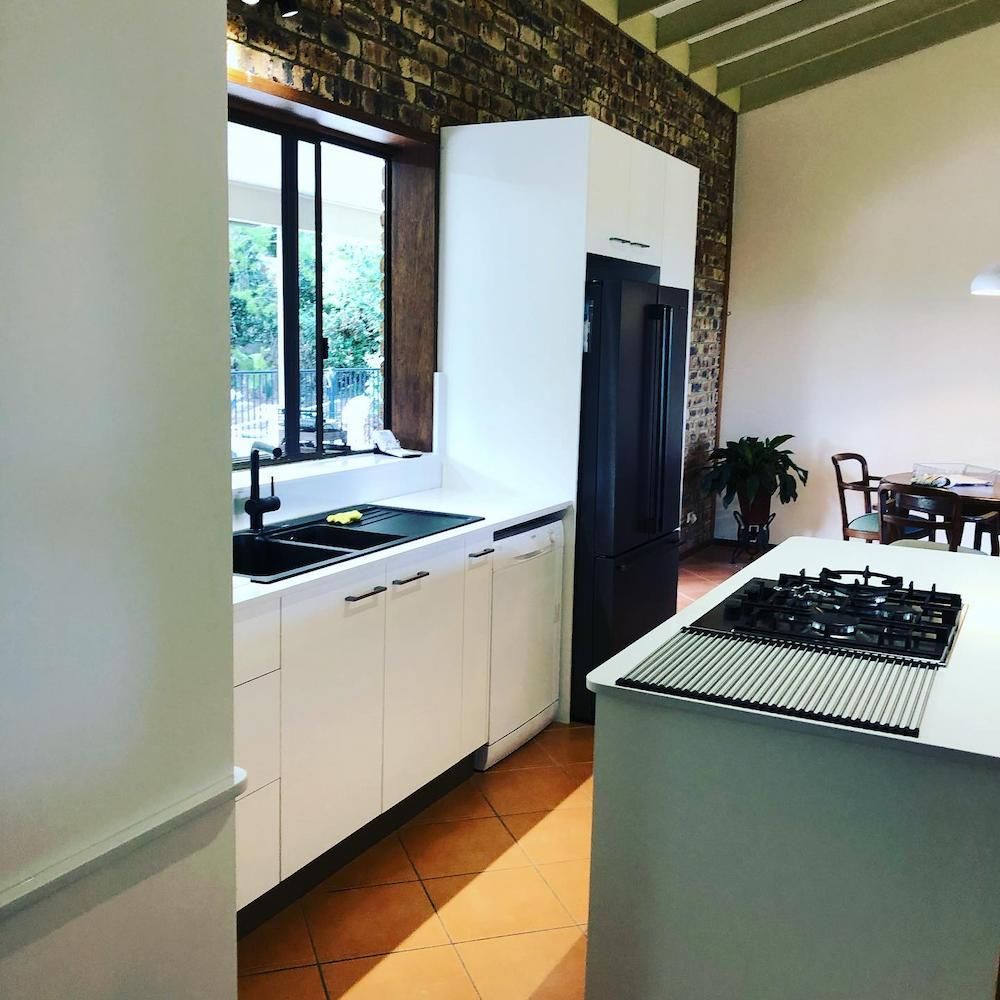 A Kitchen With White Cabinets And A Black Refrigerator — Alstonville Kitchens In Alstonville, NSW