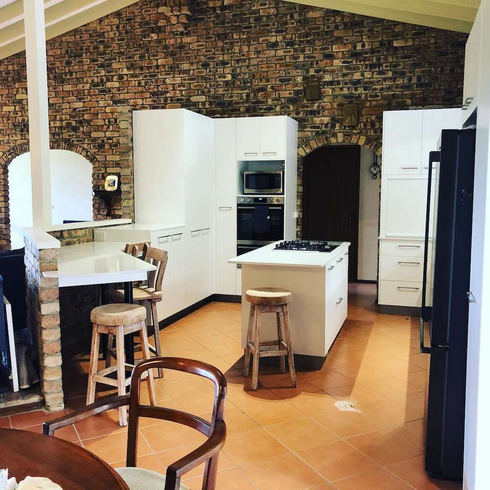 A Kitchen With White Cabinets And A Brick Wall — Alstonville Kitchens In Lismore, NSW