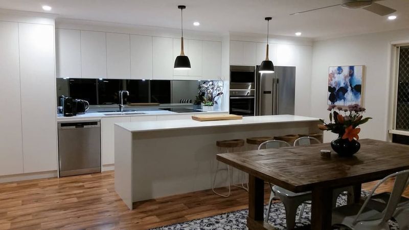 A Kitchen With White Cabinets And A Wooden Table And Chairs — Alstonville Kitchens In Alstonville, NSW