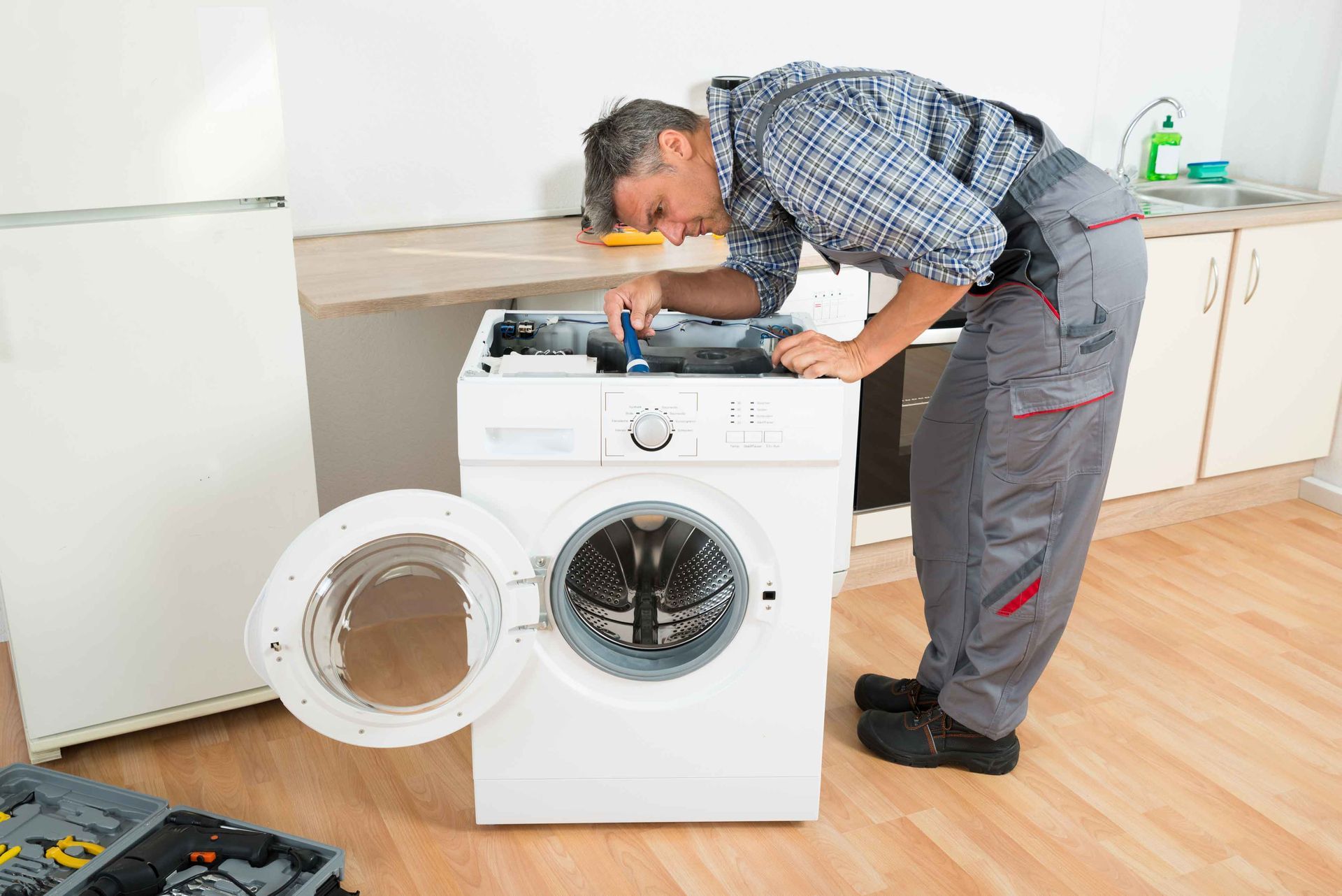 Man Repairing Washing Machine — High Point, NC — Appliance & Repair