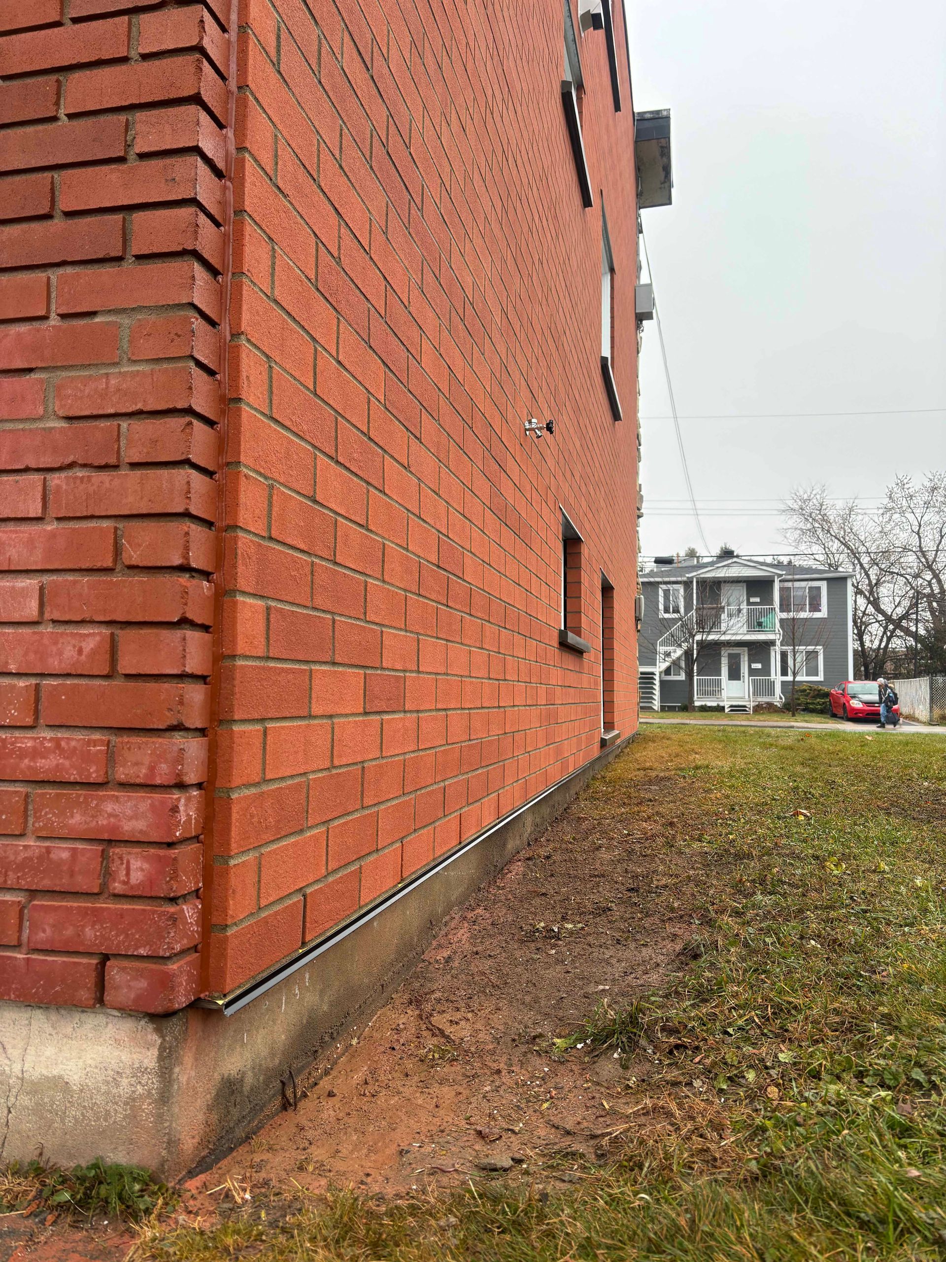 Bâtiment en briques avec un espace gazonné devant.
