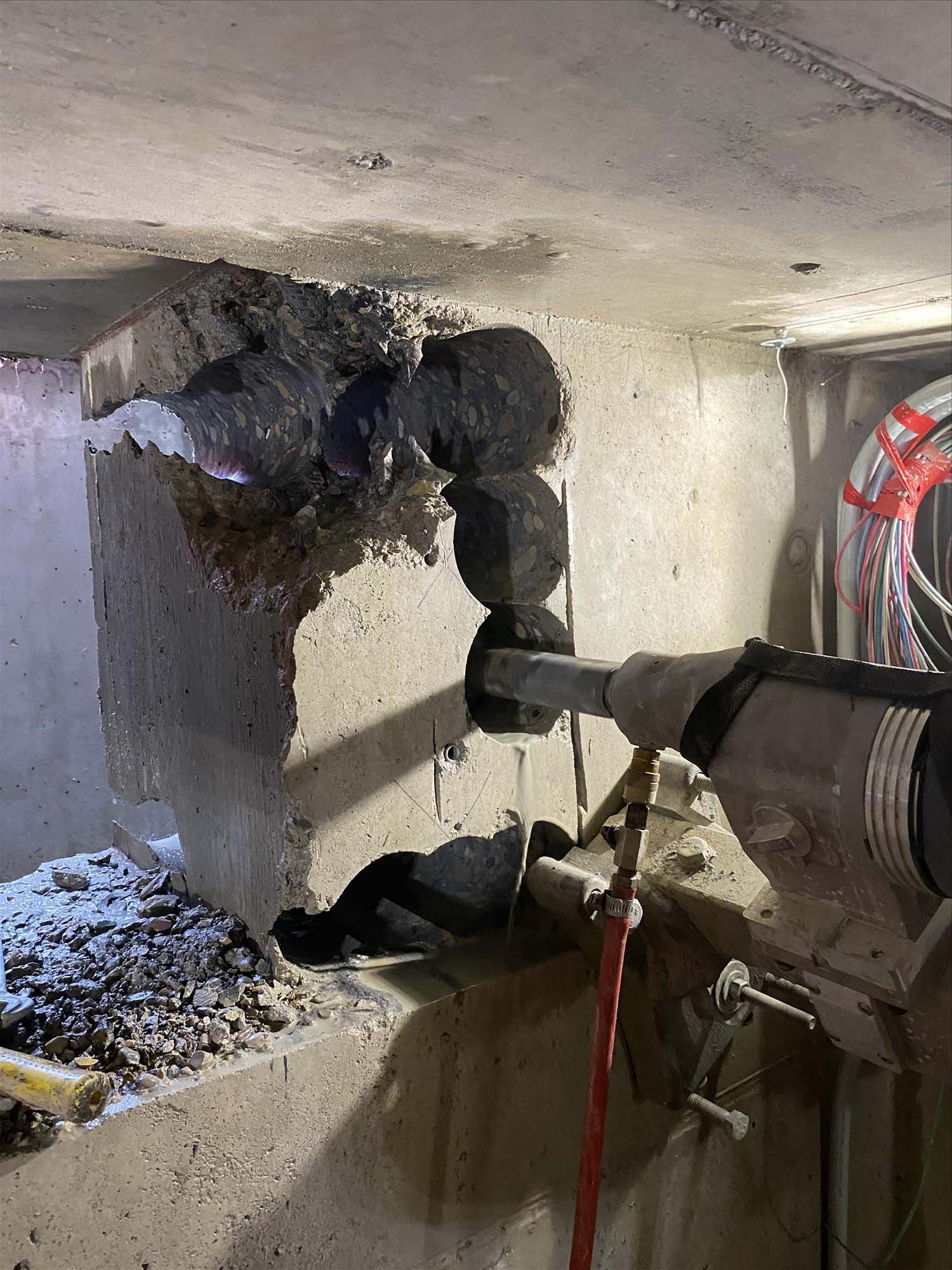 A person is using a drill to cut a hole in a wall.